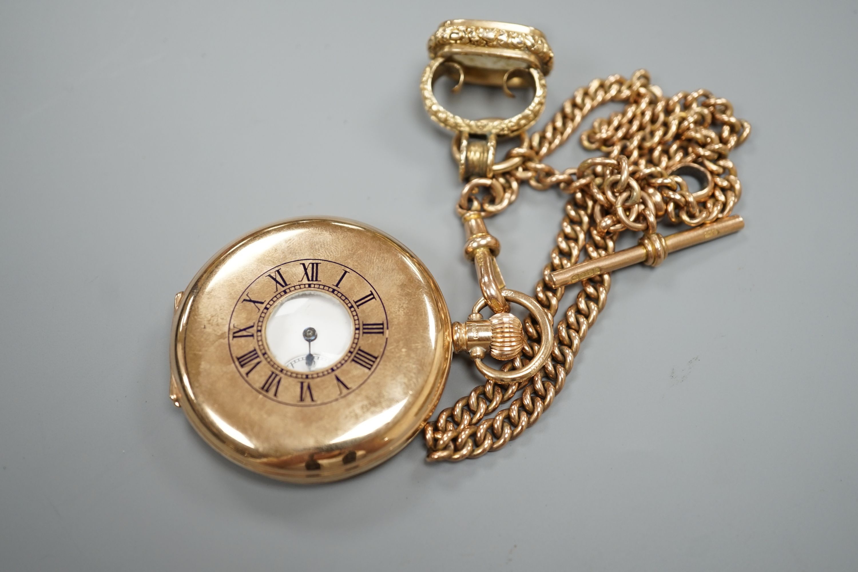 A 1920's 9ct gold Waltham keyless half hunter pocket watch, on a 9ct gold albert, hung with a Victorian yellow metal overlaid and carnelian set fob seal